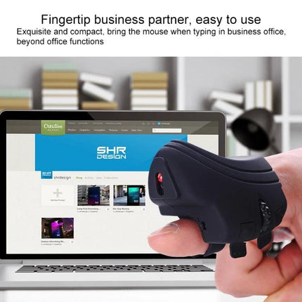 Rechargeable Finger Ring Wireless Mouse with Dual Connectivity worn on finger next to laptop for compact hands-free navigation