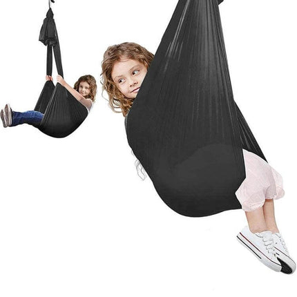 Kids Elastic Hammock Swing 100x280 cm in black stretch satin with metal hardware supporting playful child indoors