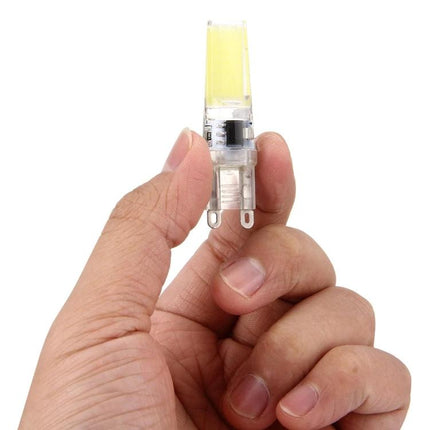 Dimmable Silicone Fixture for Daily Home and Office Lighting Needs held between fingers showing compact silicone LED bulb for adjustable home office lighting