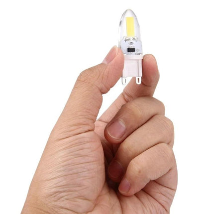 Dimmable Light Bulb for Everyday Home and Office Use held between fingers showing compact LED G4 style bulb for easy installation