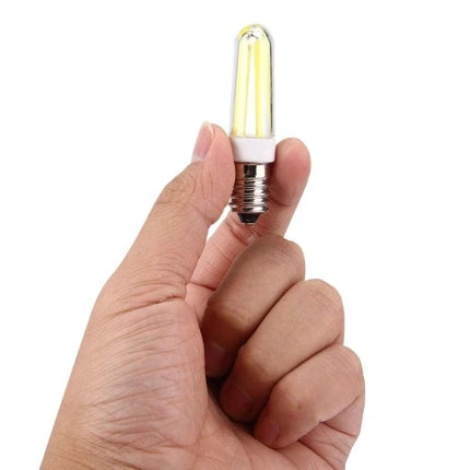 Light for Everyday Use in Home Halls and Shops LED bulb held between fingers, compact bright filament-style lamp for hallways and shop displays