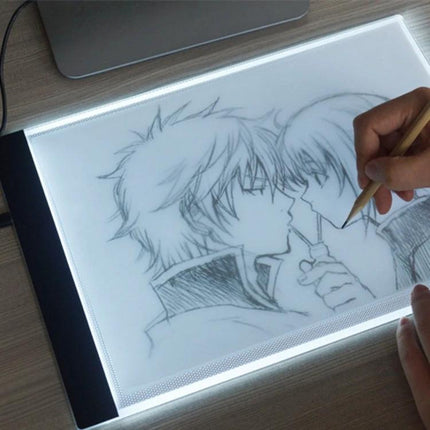 A4 Portable USB LED Tracing Light Box for Art and Design showing artist tracing anime-style sketch on slim illuminated light pad