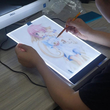 A4 Portable USB LED Tracing Light Box for Art and Design showing artist tracing anime illustration on slim illuminated A4 panel