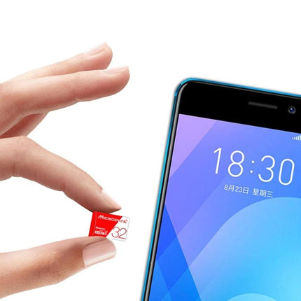 Microdata 32GB Micro SD Card for Storing Photos and Videos held between fingers next to a smartphone showing plug-and-play use