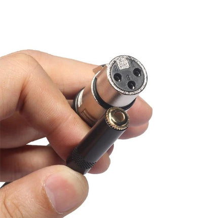 Connect Your Phone To Microphones For Everyday Audio Recording – gold-plated 3.5mm to XLR adapter held between fingers