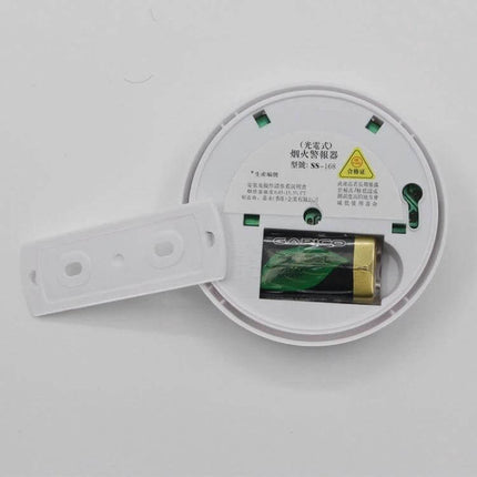 First Alert Battery-Operated Smoke Alarm for Home Safety showing open battery compartment with 9V battery installed