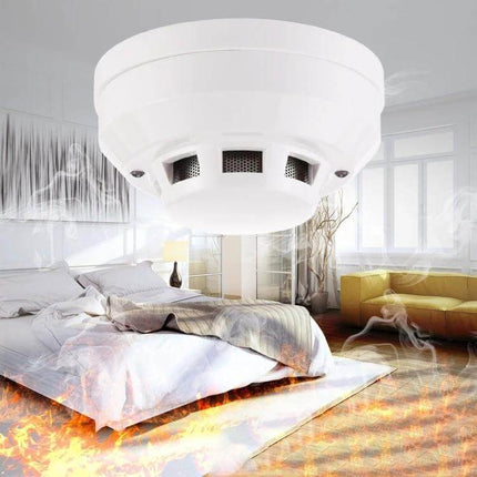 Photoelectric Smoke Detector for Home Fire Safety with Red Indicator mounted in bedroom showing smoke and flames for early warning