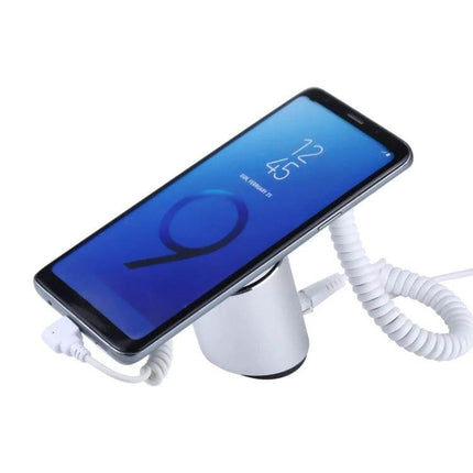 Cylindrical Display Stand for Mobile Phones with Anti-Theft Security showing phone on charging display with coiled security cable