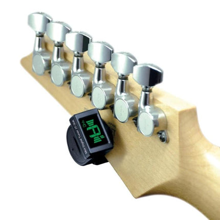 JOYO Clip-On Tuner for Everyday Instrument Practice Sessions clipped to electric guitar headstock showing green LCD tuning display