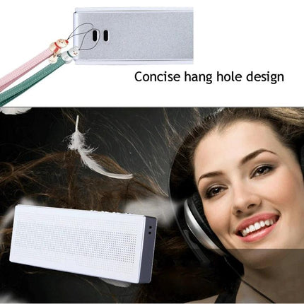 Compact Portable Bluetooth Speaker For Everyday Music showing compact white speaker, hang-hole strap and woman enjoying music