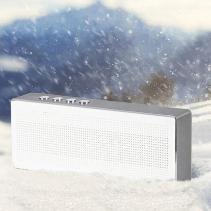 Compact Portable Bluetooth Speaker For Everyday Music shown in snowy outdoor scene, white rectangular wireless speaker with controls