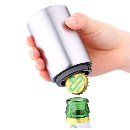 Magnetic Automatic Beer Bottle Opener Stainless Steel in hand removing cap with built-in magnet above green beer bottle