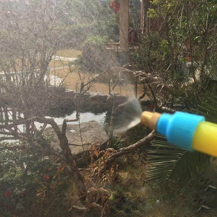 Manual Pressure Bottle Sprayer For Garden Watering spraying fine mist from a bottle-adapter over potted plants and seedlings in a backyard garden