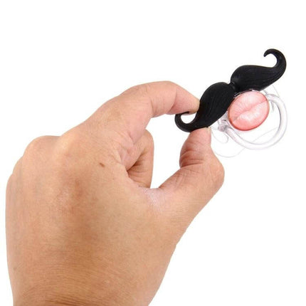 Mustache Baby Teether Soft Nipple For Soothing Gums - hand holding black mustache-shaped silicone nipple teether for soothing baby gums
