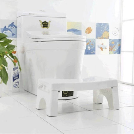 Non-Slip Toilet Foot Stool Foldable For Kids, Easy Squat Support white plastic step stool placed in front of toilet in bright bathroom