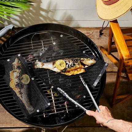 Nonstick Grill Mat 30x40 Cm For Easy Grilling On Barbecues on round grill with grilled fish and tongs, black mesh Teflon mat preventing sticking