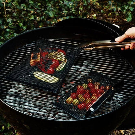 Nonstick Grill Mat 30x40 Cm For Easy Grilling On Barbecues - black teflon mat on kettle grill holding peppers, zucchini and cherry tomatoes