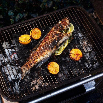 Nonstick Grill Mat 30x40 Cm For Easy Grilling On Barbecues - whole grilled fish and lemon slices on black Teflon barbecue mat
