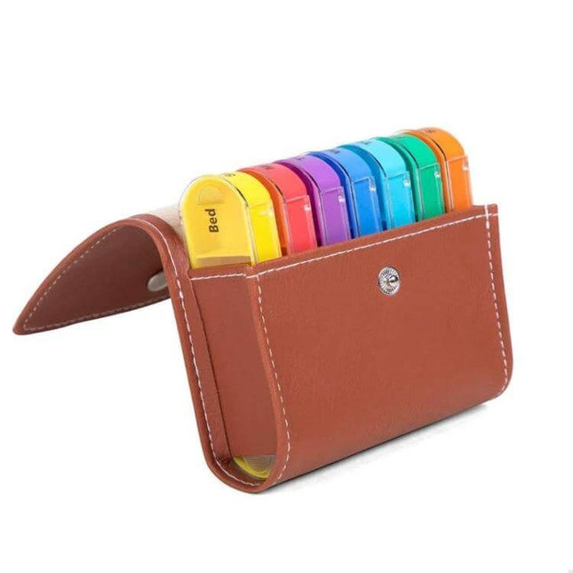 Notebook-Style 28-Compartment Portable Pill Box With Leather Bag showing seven colorful detachable four-compartment daily pill cases in a brown leather notebook organizer