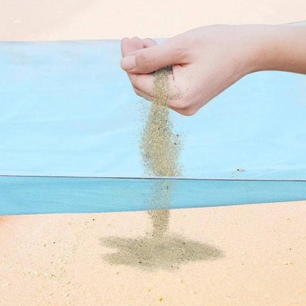 Sand Free Mat 2x2m Outdoor Picnic Beach Cushion For Outdoor Fun showing sand falling off fabric on beach to demonstrate sand-free surface