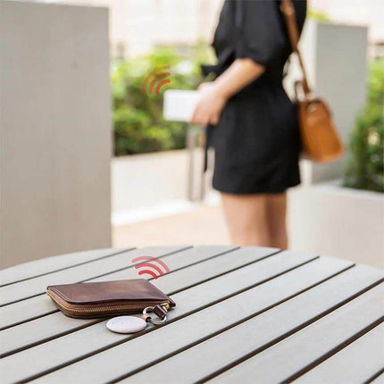 Xiaomi Youpin Bluetooth Anti-Lost Device for Tracking Items attached to a wallet on a table sending alert as owner walks away