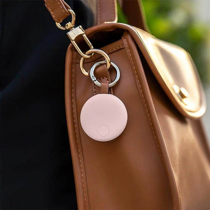 Xiaomi Youpin Bluetooth Anti-Lost Device for Tracking Items attached to a brown handbag showing compact tracker and keyring