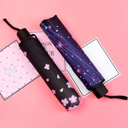 Foldable Black Waterproof Umbrella for Daily Outdoor Use - compact black umbrella with pink floral print and galaxy-patterned sleeve on pink background