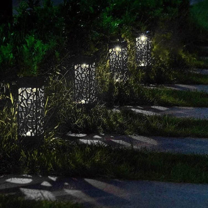 Outdoor Hollowing Out Solar Energy Garden Lawn Lamp For Pathways glowing along a garden walkway at night, decorative hollowed pattern and soft solar light
