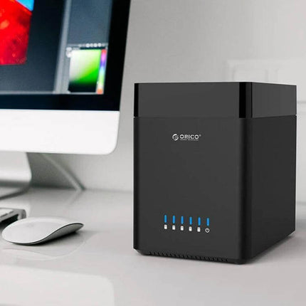 ORICO 5-Bay USB 3.0 Enclosure for 3.5-Inch Hard Drives on desk beside monitor, compact black multi-drive storage solution