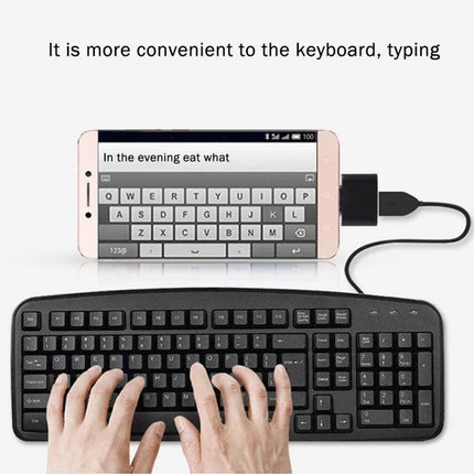Compact USB-C Adapter for Daily Device Connections and Travel connected to smartphone and keyboard for typing on the go