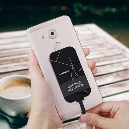 Compact NILLKIN Receiver for Daily Phone Charging attached to Type-C phone for wireless pad charging on desk