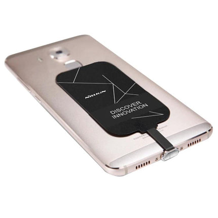 Compact NILLKIN Receiver for Daily Phone Charging attached to a Type-C phone for wireless pad charging, slim black receiver reducing cable clutter
