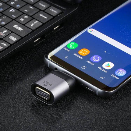 Type-C to VGA Adapter for Connecting Devices to Displays plugged into smartphone USB-C showing VGA DB15P female output
