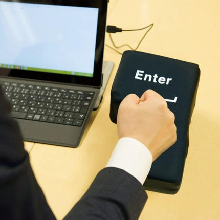 Big Enter Button USB Pillow for Relaxing at Your Desk - Black, USB-powered oversized Enter key pillow beside laptop used as input and wrist rest