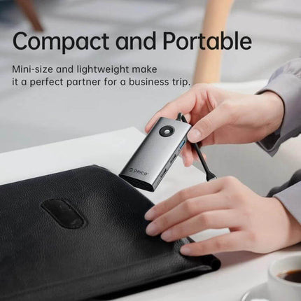 Orico 5-in-1 USB-C Docking Station for Laptop Connectivity compact portable hub being placed into a travel bag showcasing slim design and 4K HDMI