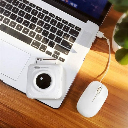 PAPERANG P1 Portable Printer for Travel Photo Printing on a laptop beside a mouse, compact Bluetooth photo printer for travelers
