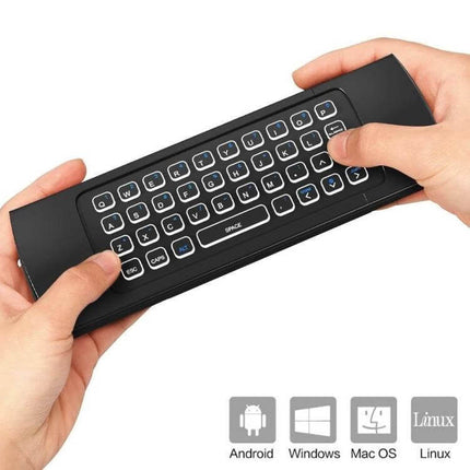 Compact Wireless Air Mouse Keyboard Remote with Voice Input and Backlight held in hands showing backlit mini QWERTY keyboard and platform icons