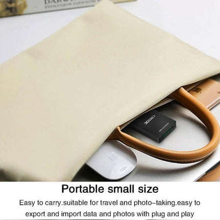Rocketek CR311 USB 3.0 XQD Card Reader for Sony and Lexar Cards - portable black card reader shown next to laptop and bag