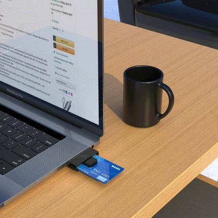 Rocketek Type-C Smart Card Reader for SIM and ID Cards connected to laptop USB-C showing inserted SIM/ID card on desk