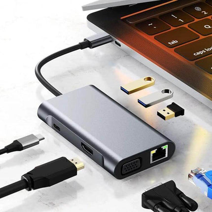 Compact USB-C 7-in-1 Docking Station for Travel and Work Connectivity — compact aluminum hub with HDMI, VGA, Ethernet and USB ports next to laptop