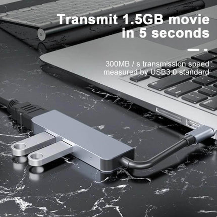 Compact USB-C Docking Station for Expanding Laptop Ports connected to a laptop on a marble desk with USB drives and HDMI cable
