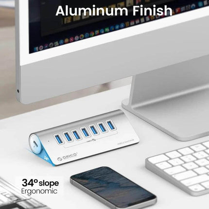 Orico Aluminum 7-Port USB Hub for Device Connections shown on desk with aluminum finish, 34° ergonomic slope and seven USB ports