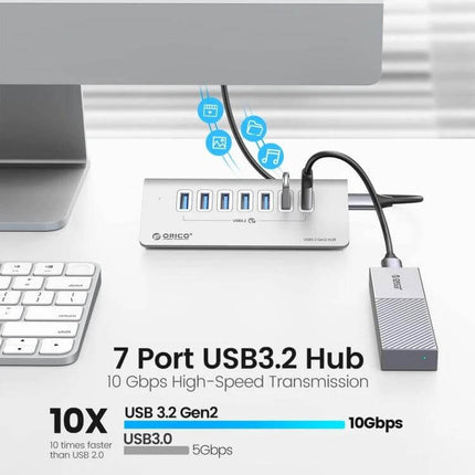 Orico Aluminum 7-Port USB Hub for Device Connections on desk with cables, external SSD and keyboard, 7-port USB 3.2 hub