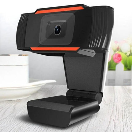 USB Webcam with Built-in Microphone for PC and Laptop Video Calls showing angled black clip-on webcam with bright orange accents on desk