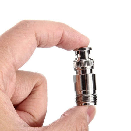 N Female to BNC Male Connector for Antennas and Cables, close-up of metallic adapter held between fingers for antenna and CCTV cable connection
