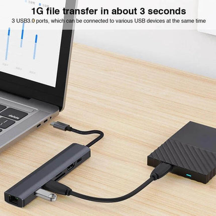 BYL 7-in-1 USB-C Docking Station for Device Connectivity Solutions connected to laptop with external drive and USB devices on desk