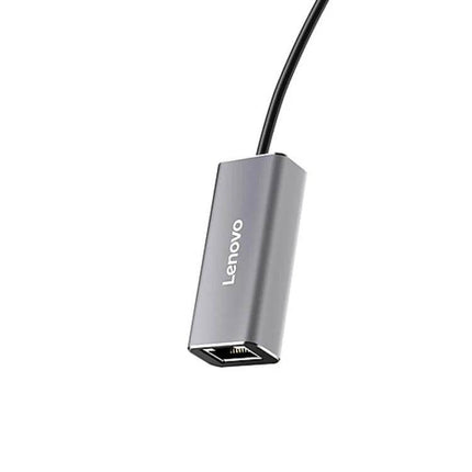 Lenovo USB-C to Gigabit Ethernet Converter for Laptops plugged into a laptop USB-C port, compact silver adapter for stable wired network