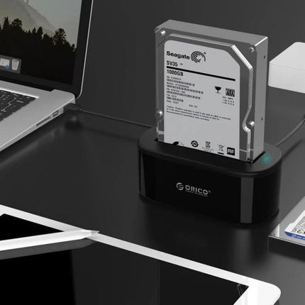 Orico External Hard Drive Dock for 2.5 and 3.5 Inch SATA Drives shown with 3.5in SATA HDD docked on desk near laptop