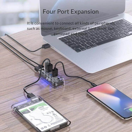 Orico Desktop USB Hub with 4 Ports and Blue LED Indicator Light connected to laptop and devices for organized desk cable management