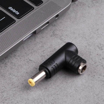 DC Adapter with 5.5x1.7mm Male to 5.5x2.5mm Female Connectors - black right-angle adapter next to laptop for bridging DC power plugs